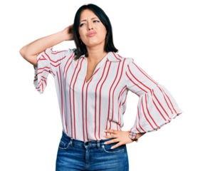 Young hispanic girl wearing casual clothes confuse and wondering about question. uncertain with doubt, thinking with hand on head. pensive concept.