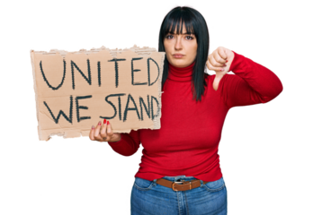 Young hispanic woman holding united we stand banner with angry face, negative sign showing dislike with thumbs down, rejection concept