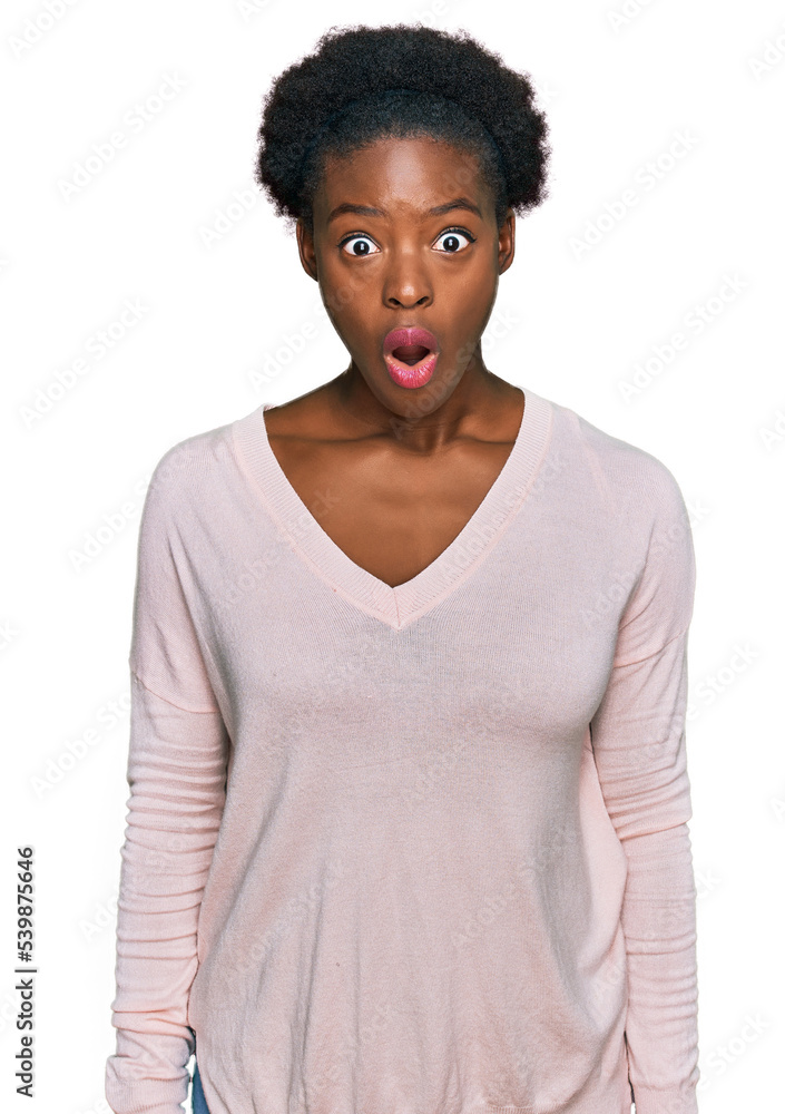 Sticker Young african american girl wearing casual clothes afraid and shocked with surprise and amazed expression, fear and excited face.