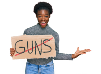 Young african american girl holding no guns warning banner celebrating victory with happy smile and winner expression with raised hands