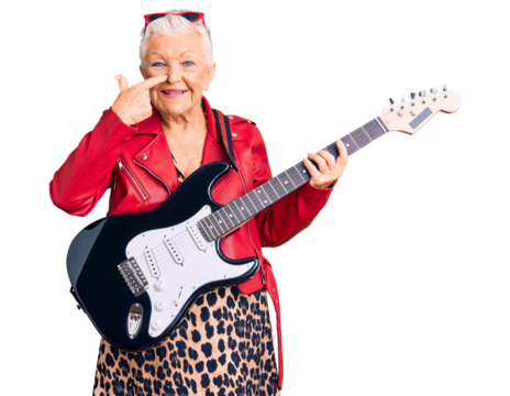 Senior beautiful woman with blue eyes and grey hair wearing a modern look playing electric guitar pointing with hand finger to face and nose, smiling cheerful. beauty concept