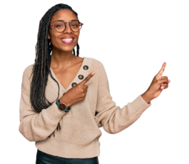 African american woman wearing casual clothes smiling and looking at the camera pointing with two hands and fingers to the side.
