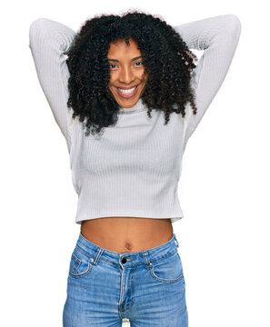 Young african american girl wearing casual clothes relaxing and stretching, arms and hands behind head and neck smiling happy