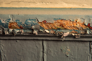 Many layers of old lead paint chipping off wall in home covered with dangerous lead dust