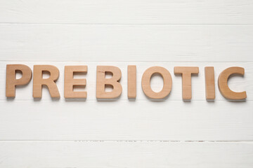 Word Prebiotic made of letters on white wooden table, top view