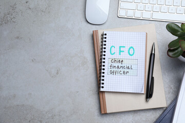 Notebook with CFO abbreviation and space for text on grey office table, flat lay. Financial...