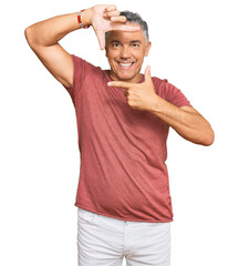 Fototapeta premium Handsome middle age man wearing casual clothes smiling making frame with hands and fingers with happy face. creativity and photography concept.