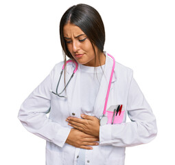 Beautiful hispanic woman wearing doctor uniform and stethoscope with hand on stomach because indigestion, painful illness feeling unwell. ache concept.