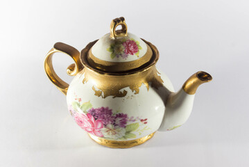 Unique teapot and glass with gold ornaments and white background