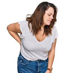 Fototapeta premium Young plus size woman wearing casual white t shirt suffering of backache, touching back with hand, muscular pain