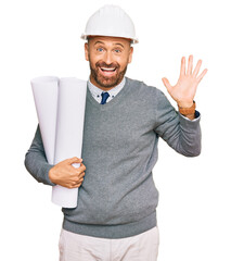 Handsome middle age man holding paper blueprints celebrating victory with happy smile and winner...