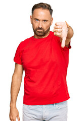 Handsome middle age man wearing casual red tshirt looking unhappy and angry showing rejection and...