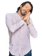 Middle age handsome man wearing business shirt sleeping tired dreaming and posing with hands together while smiling with closed eyes.