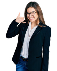 Young caucasian girl wearing business style and glasses smiling doing phone gesture with hand and fingers like talking on the telephone. communicating concepts.