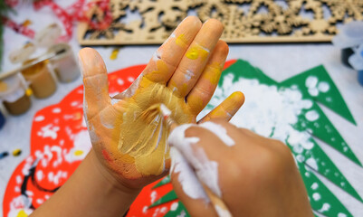 Mischief child making a greeting card and painting on own hands. Creativity with kids and art therapy