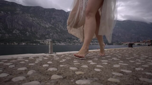 Bride runs barefoot along the pier by the sea