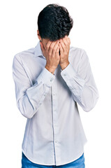 Young hispanic business man wearing business clothes with sad expression covering face with hands while crying. depression concept.