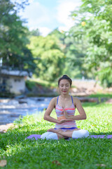 A beautiful young girl doing yoga in the park in the morning., peace and relaxation, woman's happiness