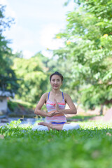 A beautiful young girl doing yoga in the park in the morning., peace and relaxation, woman's happiness