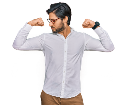 Young hispanic man wearing business shirt and glasses showing arms muscles smiling proud. fitness concept.