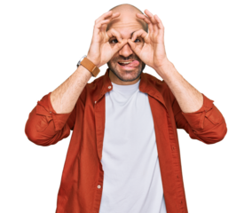 Young hispanic man wearing casual clothes doing ok gesture like binoculars sticking tongue out, eyes looking through fingers. crazy expression.