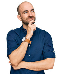 Young hispanic man wearing casual clothes with hand on chin thinking about question, pensive...