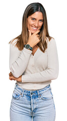 Young woman wearing casual clothes looking confident at the camera smiling with crossed arms and hand raised on chin. thinking positive.
