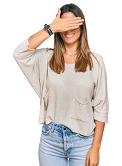 Fototapeta premium Young woman wearing casual clothes and glasses smiling and laughing with hand on face covering eyes for surprise. blind concept.