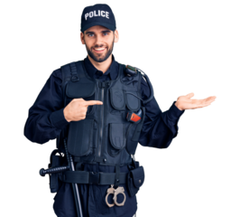 Young handsome man with beard wearing police uniform amazed and smiling to the camera while presenting with hand and pointing with finger.