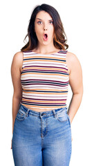 Fototapeta premium Beautiful young brunette woman wearing casual clothes scared and amazed with open mouth for surprise, disbelief face