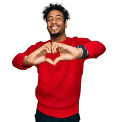 Young african american man with beard wearing casual winter sweater smiling in love doing heart...