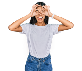 Beautiful young asian woman wearing casual white t shirt doing ok gesture like binoculars sticking tongue out, eyes looking through fingers. crazy expression.