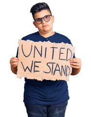 Little boy kid holding united we stand banner thinking attitude and sober expression looking self confident