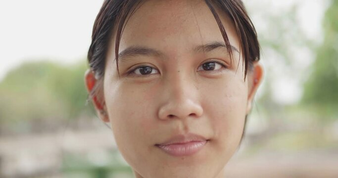Face of beautiful asian woman with natural make-up looking at camera, Slow motion
