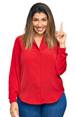 Beautiful brunette woman wearing casual clothes pointing finger up with successful idea. exited and happy. number one.