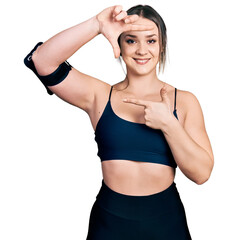 Fototapeta na wymiar Young hispanic woman wearing sportswear smiling making frame with hands and fingers with happy face. creativity and photography concept.