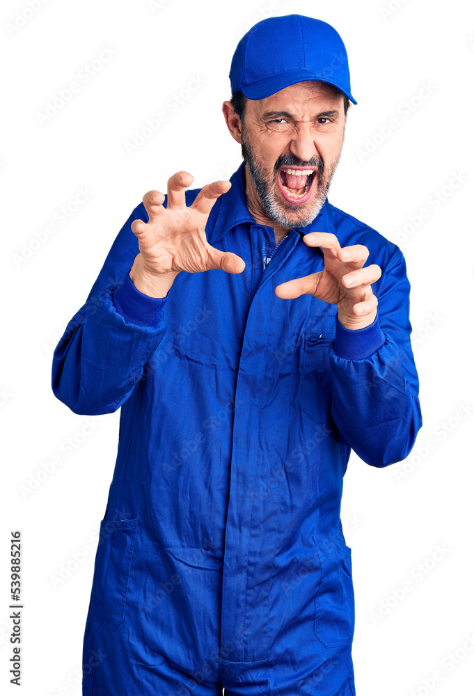 Canvas Prints middle age handsome man wearing mechanic uniform smiling funny doing claw gesture as cat, aggressive