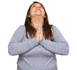 Beautiful brunette plus size woman wearing casual clothes begging and praying with hands together with hope expression on face very emotional and worried. begging.