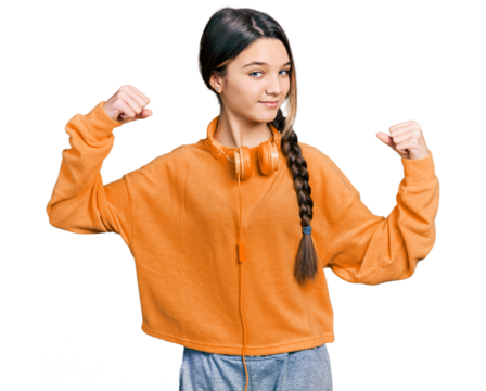 Young brunette girl with long hair wearing sweatshirt and headphones showing arms muscles smiling proud. fitness concept.