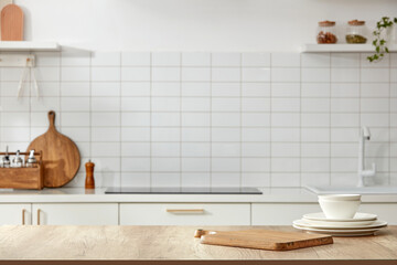View on white kitchen in scandinavian style, wooden cutting board, dishes on the wooden table. 