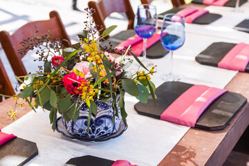 Country set table decoration with colorful flowers in a sunny day at park