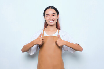 Smiling pretty young barista girl in apron showing thumb up have good mood isolated on white background