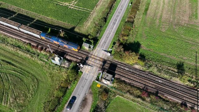 Cargo Train Passing Over a Level Crossing with Vehicles