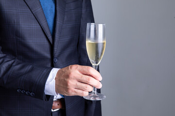 シャンパングラスを持ったスーツの男性