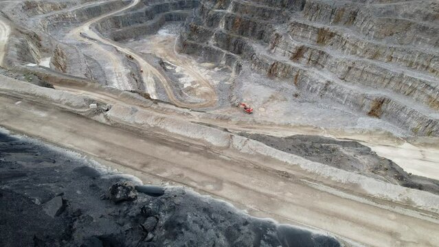 Aerial drone tilt down shot over Hanson Aggregates Quarry site in Harrogate, North Yorkshire, England, UK on a sunny day.