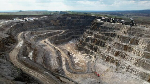 Aerial drone forward moving shot over Hanson Aggregates Quarry site in Harrogate, North Yorkshire, England, UK on a sunny day.