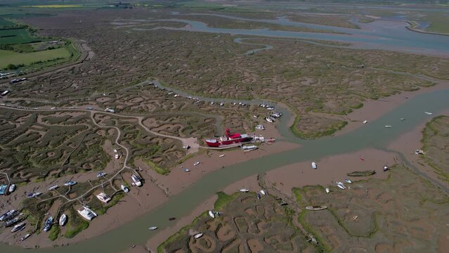 Aerial view over the stranded LV15 Trinity Lightvessel, sunny Tollesbury, UK - tilt, drone shot