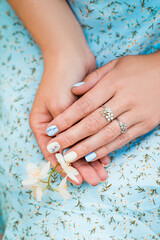 Female hands with flower on floral blue background