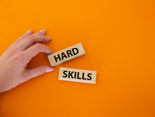 Hard skills symbol. Wooden blocks with words Hard skills. Beautiful orange background. Businessman hand. Business and Hard skills concept. Copy space.
