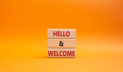 Hello and Welcome symbol. Concept words Hello and Welcome on wooden blocks. Beautiful orange background. Business and Hello and Welcome concept. Copy space.